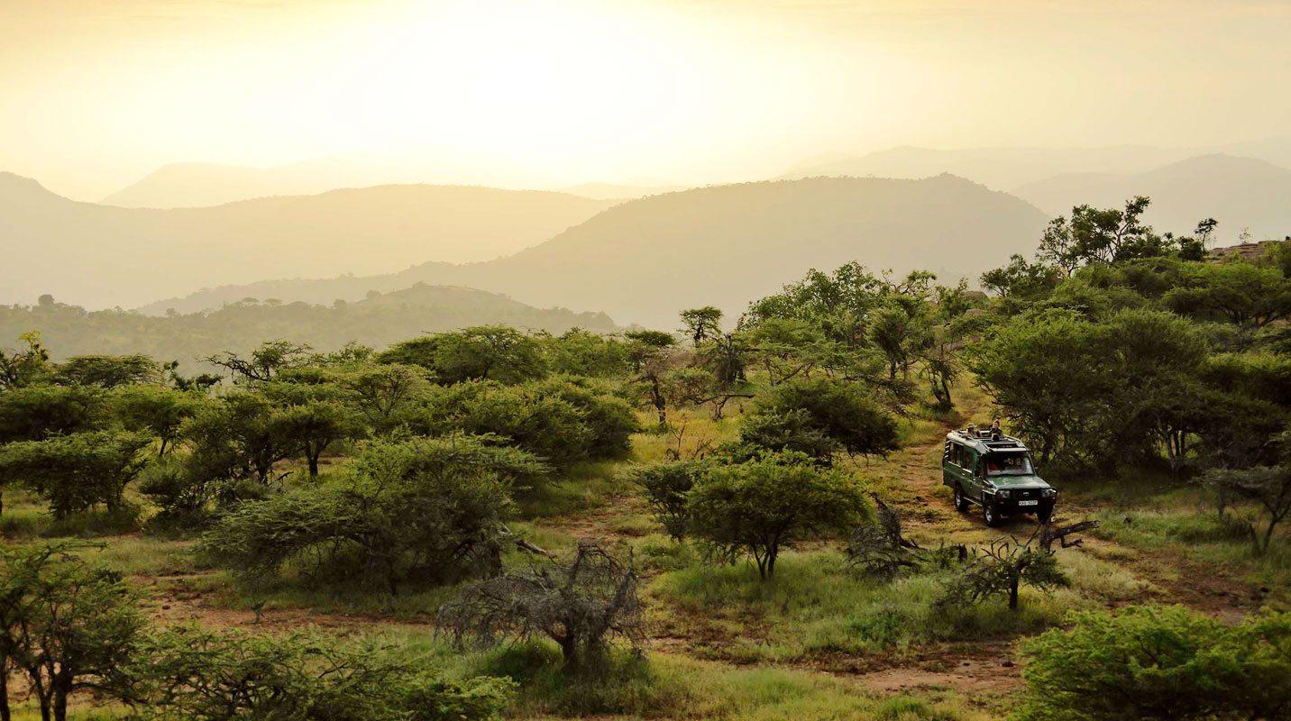 Laikipia landscape at golden hour — safari vehicle on a track in Kenya