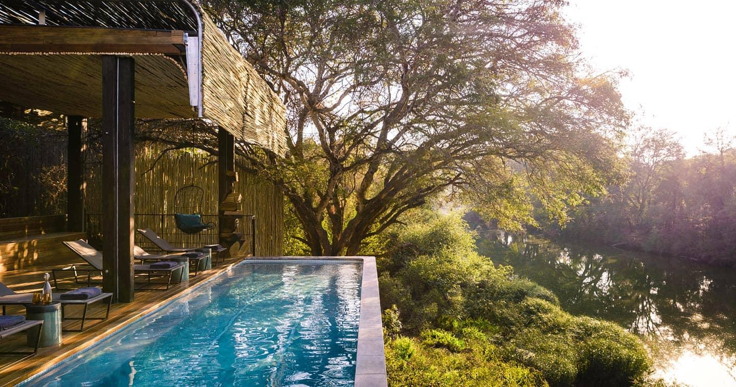 Pool at a luxury safari lodge South Africa with views over a river and lush green bush
